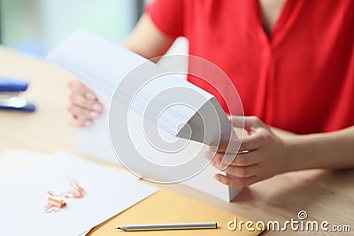 Close-up of office manager holding stack of blank paper while sitting at desk. Stock Photo