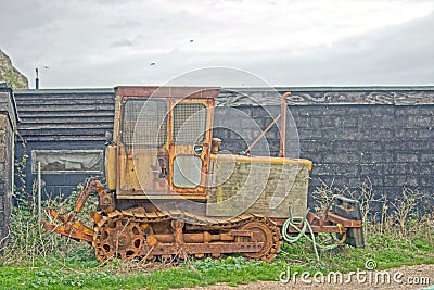 A close up of a of a old Bull dozer abandoned by a old shed Editorial Stock Photo