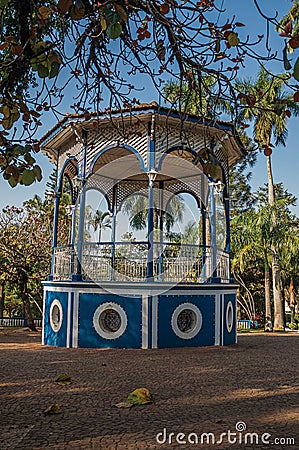 Close-up of an old colorful gazebo in the middle of verdant garden full of trees, in a sunny day at SÃ£o Manuel. Stock Photo