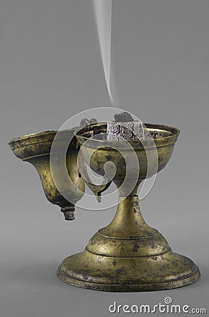 Close-up old incense burner with burning resin incense on hot coal. Using for burning resin incenses like myrrh, benzoin or franki Stock Photo