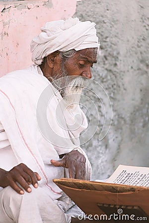 Close up of an old indian sadhu reading scriptures. Stock Photo
