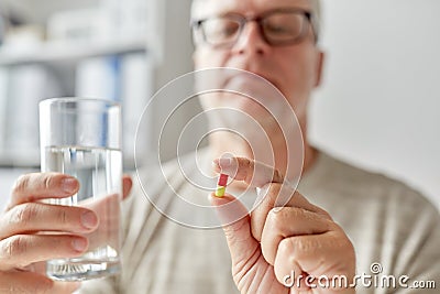 Close up of old man hands with pill and water Stock Photo