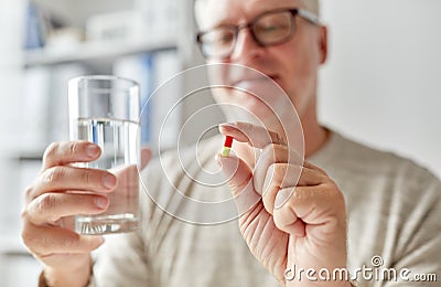 Close up of old man hands with pill and water Stock Photo