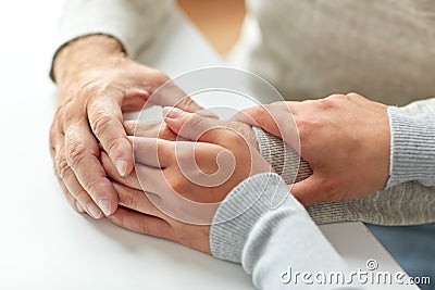 Close up of old man and young woman holding hands Stock Photo