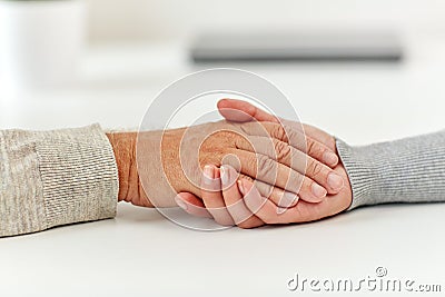 Close up of old man and young woman holding hands Stock Photo