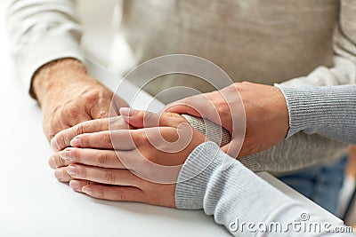 Close up of old man and young woman holding hands Stock Photo