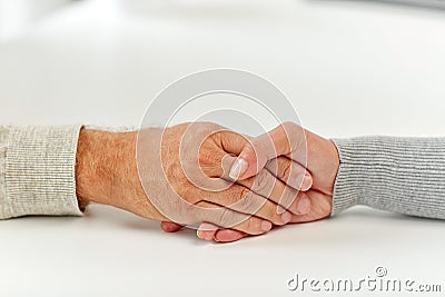 Close up of old man and young woman holding hands Stock Photo