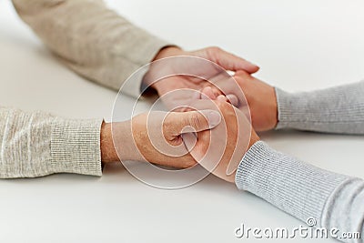 Close up of old man and young woman holding hands Stock Photo