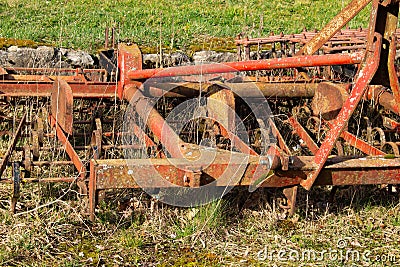 Close up of a old red and rusty cultivator used for cultivating agricultural land Stock Photo