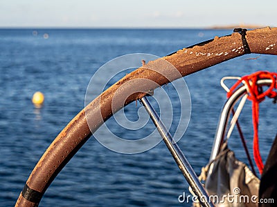 Close up of an old sailboat helm with the ocean in the background. Stock Photo