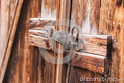 Old simple lock on a wooden door closed with a metal pin rustic latch on an old door made of wood Stock Photo