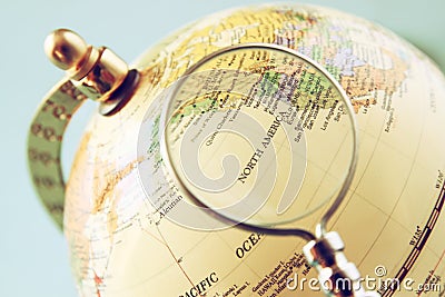 Close up of old vintage globe and magnifying glass Stock Photo