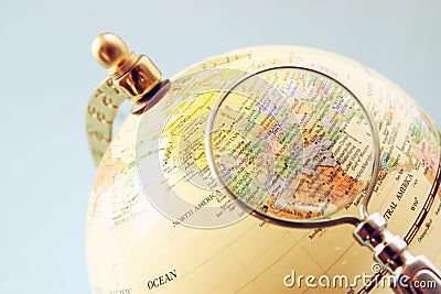 Close up of old vintage globe and magnifying glass Stock Photo
