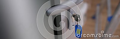 Open door with steel lock and keys with number tag Stock Photo