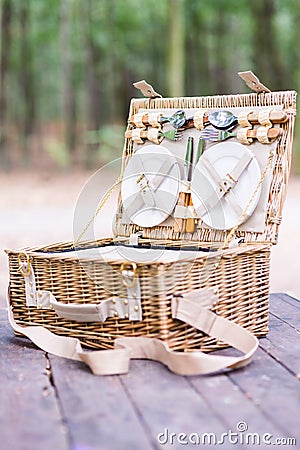 Close up of an open picnic basket over wooden table in the park. Stock Photo