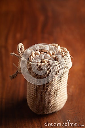 Close-up of Organic small chhole chana or Kabuli chana Cicer arietinum or whole white Bengal gram dal in a standing jute bag Stock Photo