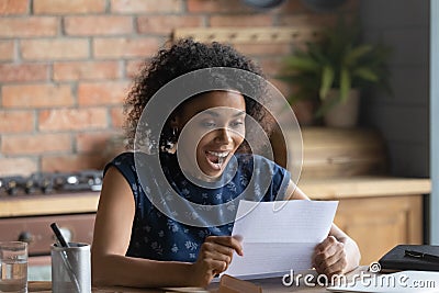 Close up overjoyed African American woman reading letter Stock Photo