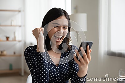 Close up overjoyed Asian woman reading good news, celebrating success Stock Photo