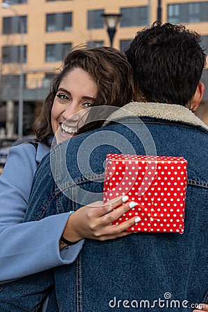 Close up overjoyed wife hugging husband, thanking for romantic present, surprise, happy attractive young woman holding gift box , Stock Photo