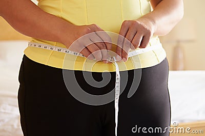 Close Up Of Overweight Woman Measuring Waist Stock Photo