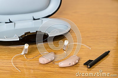 Close up of a pair of tiny modern hearing aid on bedside table Stock Photo