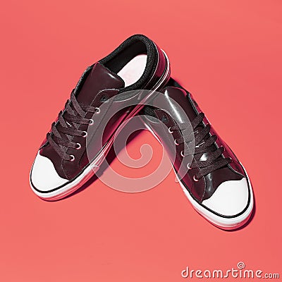 Close-up of pair of vintage sneakers shoes on coral pink background. Stock Photo