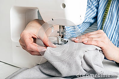 Close-up partial view of seamstress working with sewing machine Stock Photo