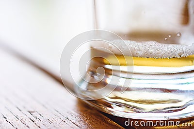 Close-Up Of Partially Finished Cold Glass Of Beer With Frothy Foam And Bubbles On Rough Wooden Table Stock Photo