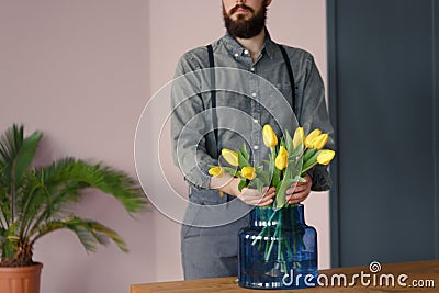 Close-up of passionate gardener taking care of yellow flowers in Stock Photo