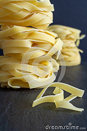 Close-up of pasta with pile of fettuccine defocused posterior on black background Stock Photo