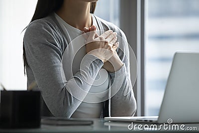 Close up peaceful wishful businesswoman holding hands on chest Stock Photo