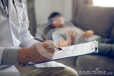 Close up of pen doctor writing with came to visit the patient at home while he was suffering from stomach ulcers and noted the tre Stock Photo