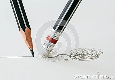 Close up of a pencil eraser removing a crooked line and the close up of a sharpened pencil writing a straight line. Stock Photo