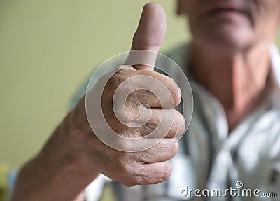 Close-up Pensioner shows thumbs up. A positive elderly man held out his hand and showed a thumbs up. Selective focus Stock Photo