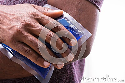 Person Applying Ice Gel Pack On An Elbow Stock Photo