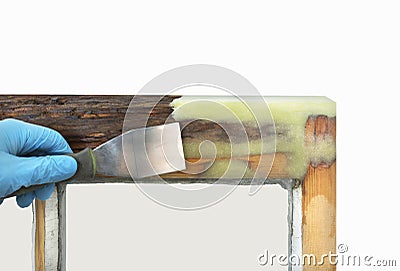 Person applying resin with spatula to old sash window Stock Photo