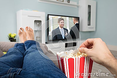 Person Watching Movie While Eating Popcorn Stock Photo