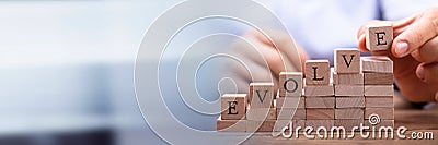 Person's Hand Placing Last Alphabet Of Word Evolve Stock Photo