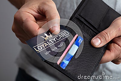 Person Removing Loyalty Card From Wallet Stock Photo