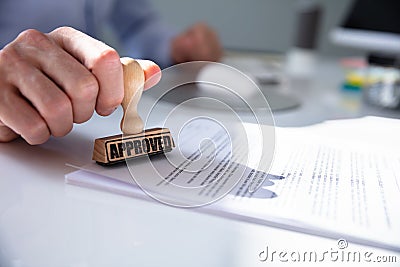 Person`s Hand Stamping With Approved Stamp Stock Photo