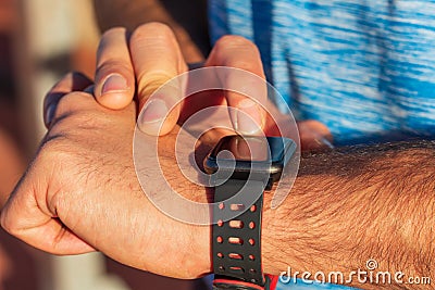 Close-up of a person`s hands using their smart watch to access their mobile phone from the app.Health, technology, sport, Stock Photo