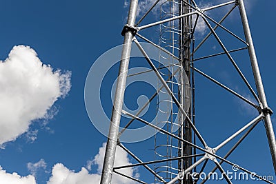 Close up perspective pov of modern metal steel mobile 5g network wireless telecom tower against clear blue sky Stock Photo