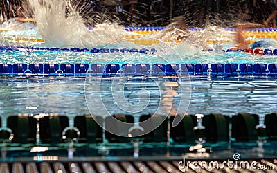 Close up photo of blue lane in swimming pool, blurry water splashes from fast freestyle swimmers Stock Photo