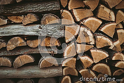 Close up photo of chumps of wood - symmetric stored. Dark textured and stacked firewood background Stock Photo