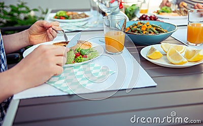 Close up photo of hands man eating salad, quinoa and fish on terrace Stock Photo