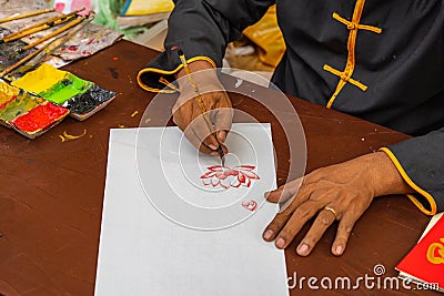 Close up photo of human hand using chinese calligraphy brush and painting Stock Photo