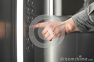 Close up photo, man pushes the floor button in the elevator. Business man hand pressing the button in the elevator. Background. Stock Photo