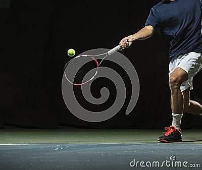 Close up photo of a man swinging a tennis racquet during a tennis match Stock Photo