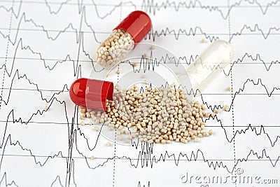 Close-up photo of open capsule with medicine on EKG graph Stock Photo