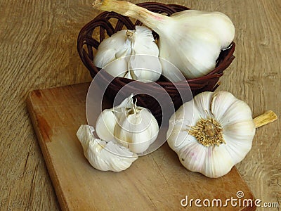 Close up Photo of Organic Whole Garlic with some Unpeeled Cloves and a clove of garlic on oak tree wood background. Stock Photo